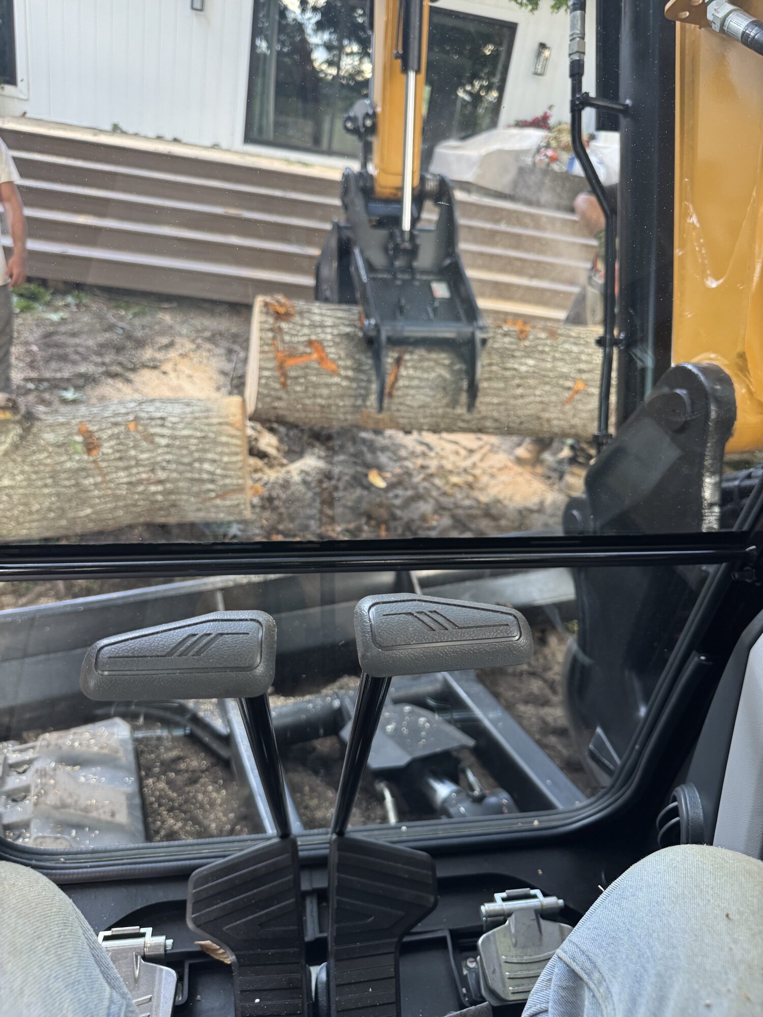 Grapple holding cut oak trunk sections during fallen tree and debris cleanup in Rhodesdale, Maryland